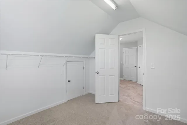 a view of an empty room with chandelier fan and a window