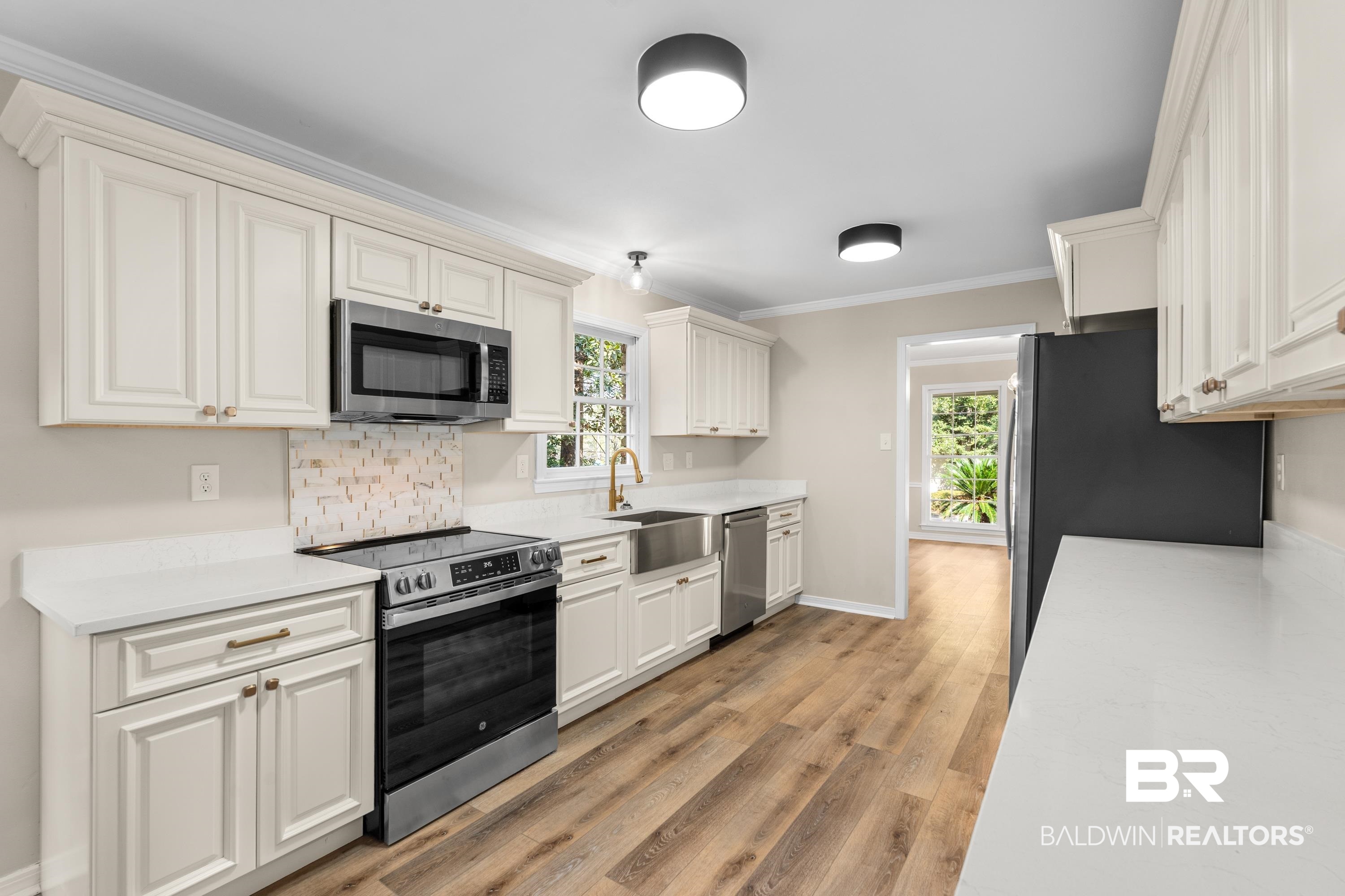 728 Spring Station Road Mobile, AL 36609 - Photo 9 of 35 Kitchen featuring ornamental molding, stainless steel appliances, tasteful backsplash, light wood-style floors, and light stone countertops