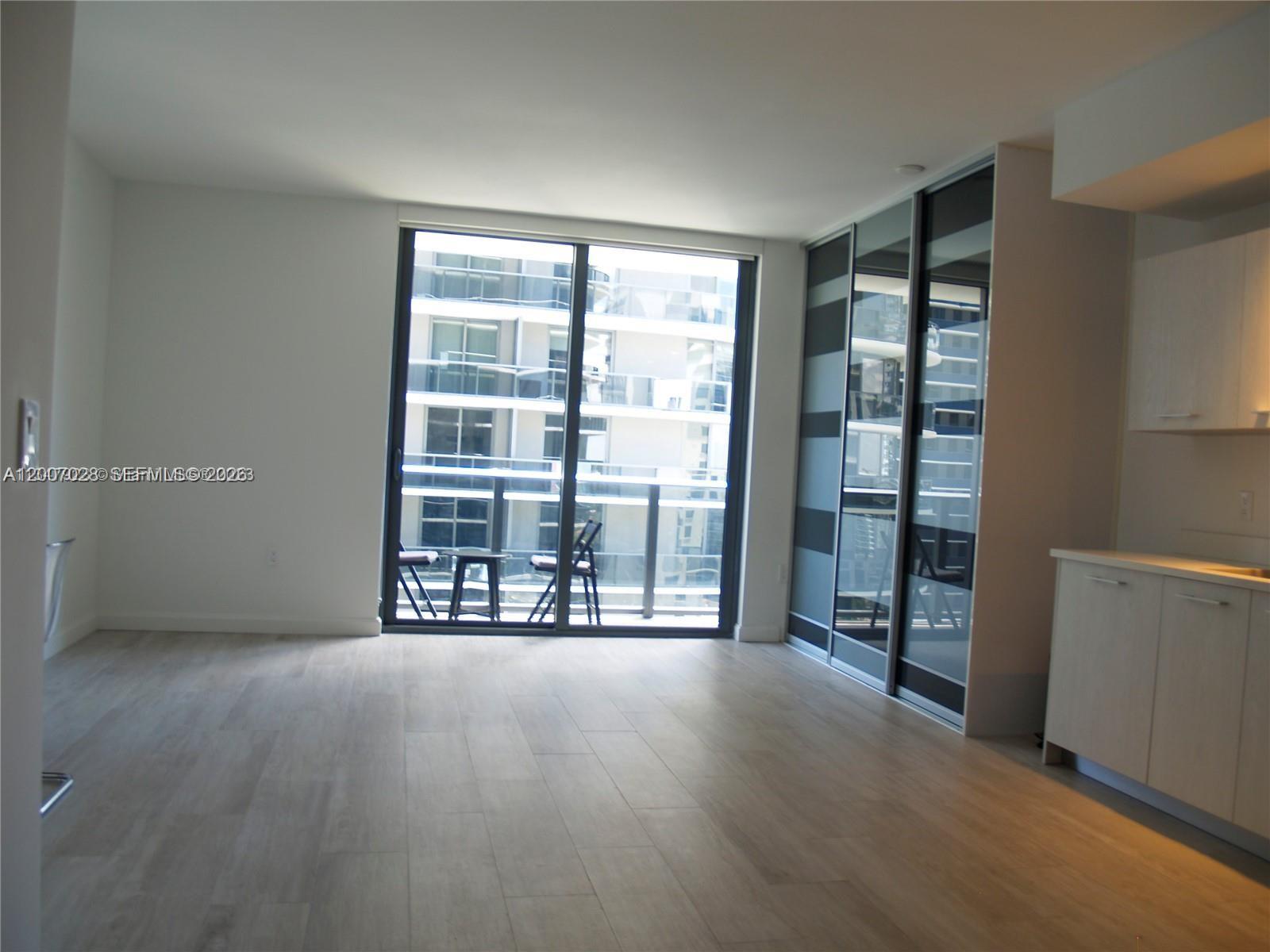 55 Southwest 9th Street, Unit 2502 Miami, FL 33130 - Photo 2 of 27 an empty room with wooden floor and windows