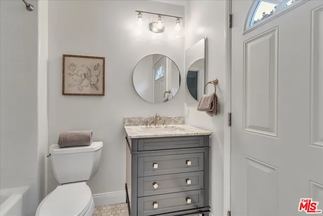 a bathroom with a toilet a sink and a mirror