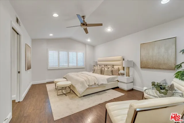 a bedroom with a bed chandelier and couch