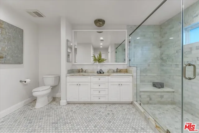 a bathroom with a double vanity sink toilet and shower