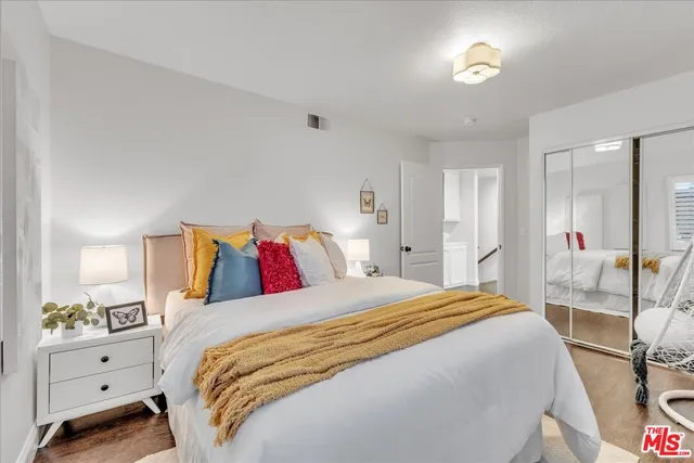 a bedroom with a bed and a table with wooden floor