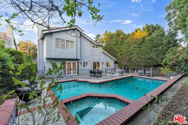 a view of a house with swimming pool and sitting area
