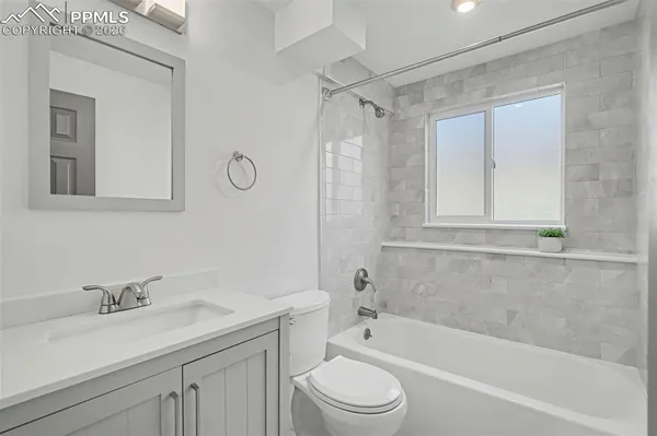 a bathroom with a granite countertop sink a toilet and shower