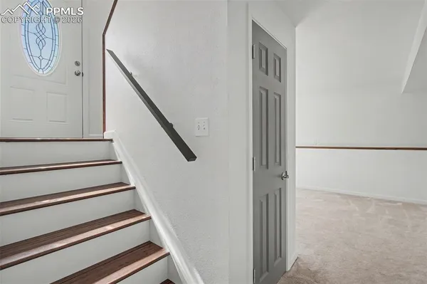 a view of staircase with white walls and a window
