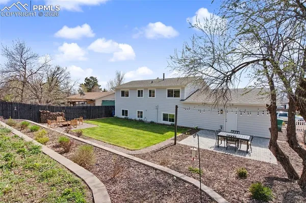 a view of a house with backyard and sitting area