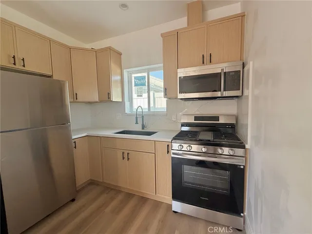 a kitchen with stainless steel appliances a stove a microwave and a refrigerator