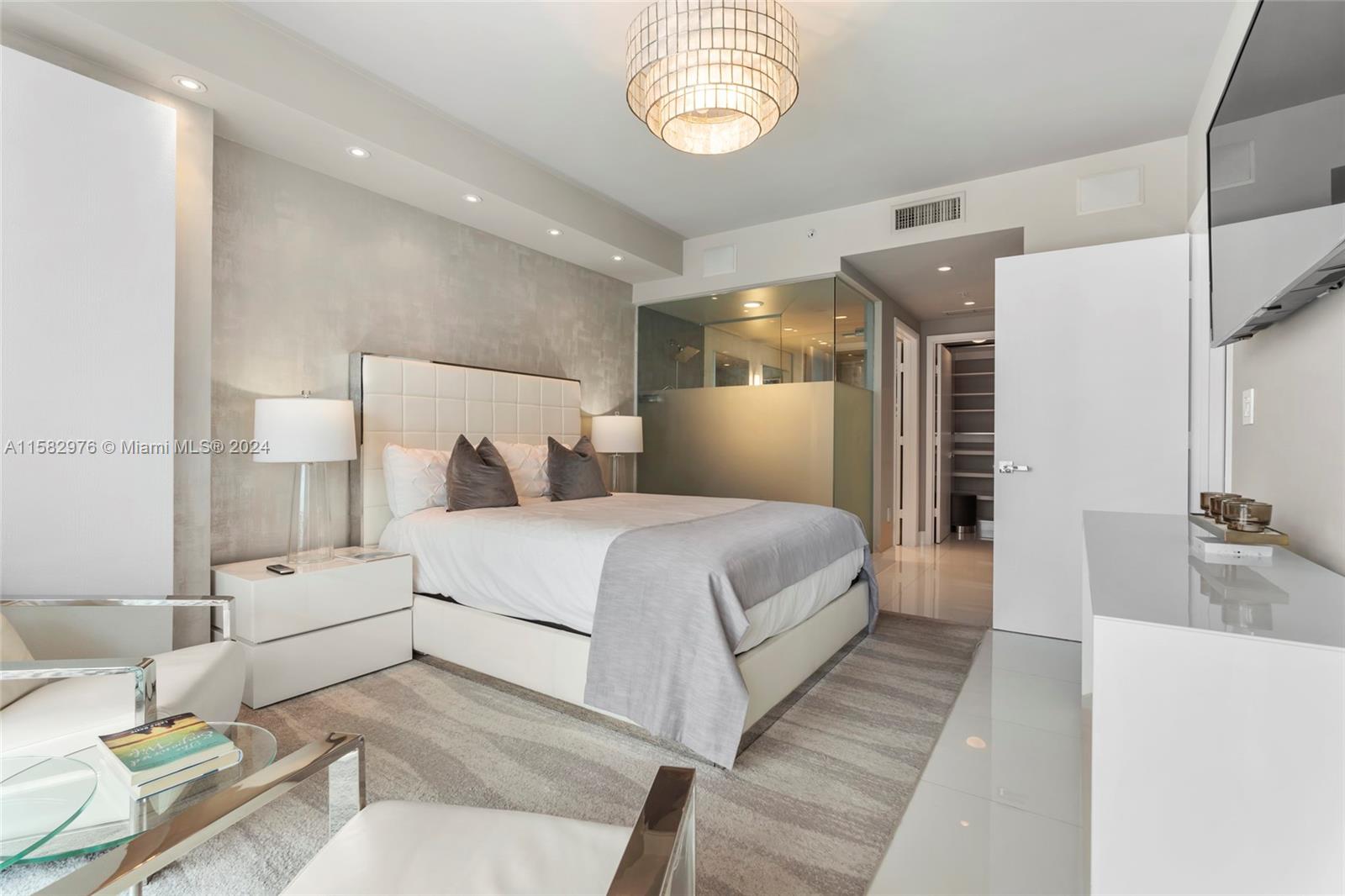 92 Southwest 3rd Street, Unit 2303 Miami, FL 33130 - Photo 20 of 35 a bedroom with a bed and a chandelier