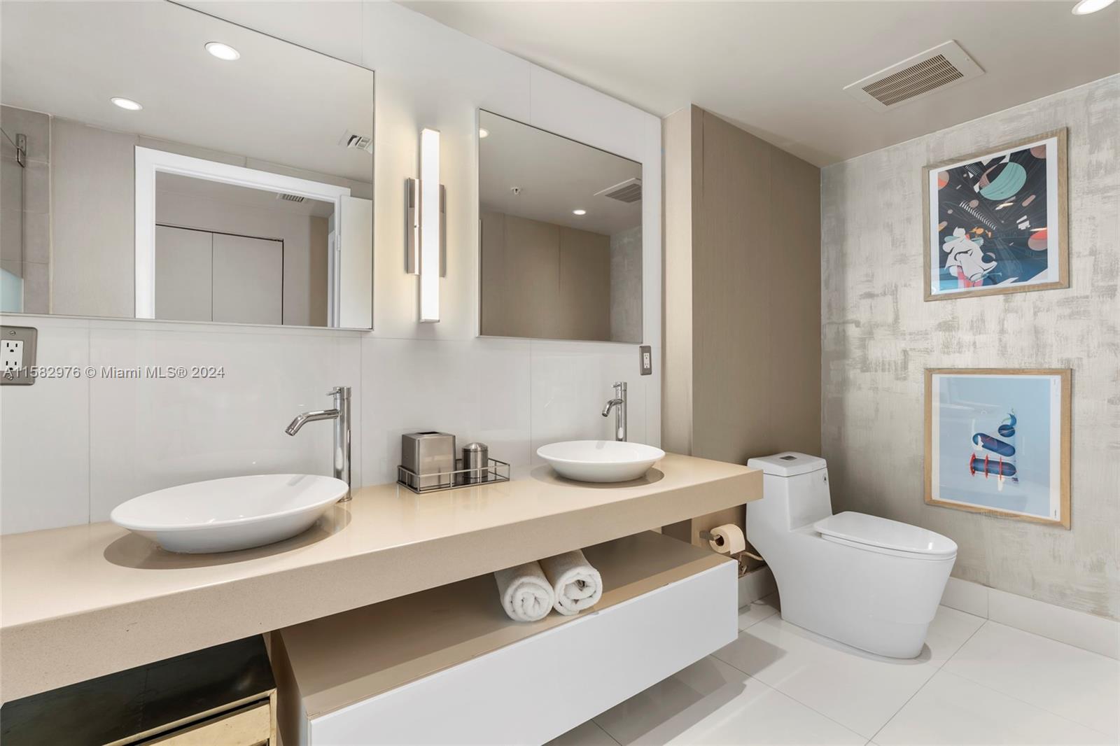 92 Southwest 3rd Street, Unit 2303 Miami, FL 33130 - Photo 21 of 35 a bathroom with a sink a toilet and a mirror