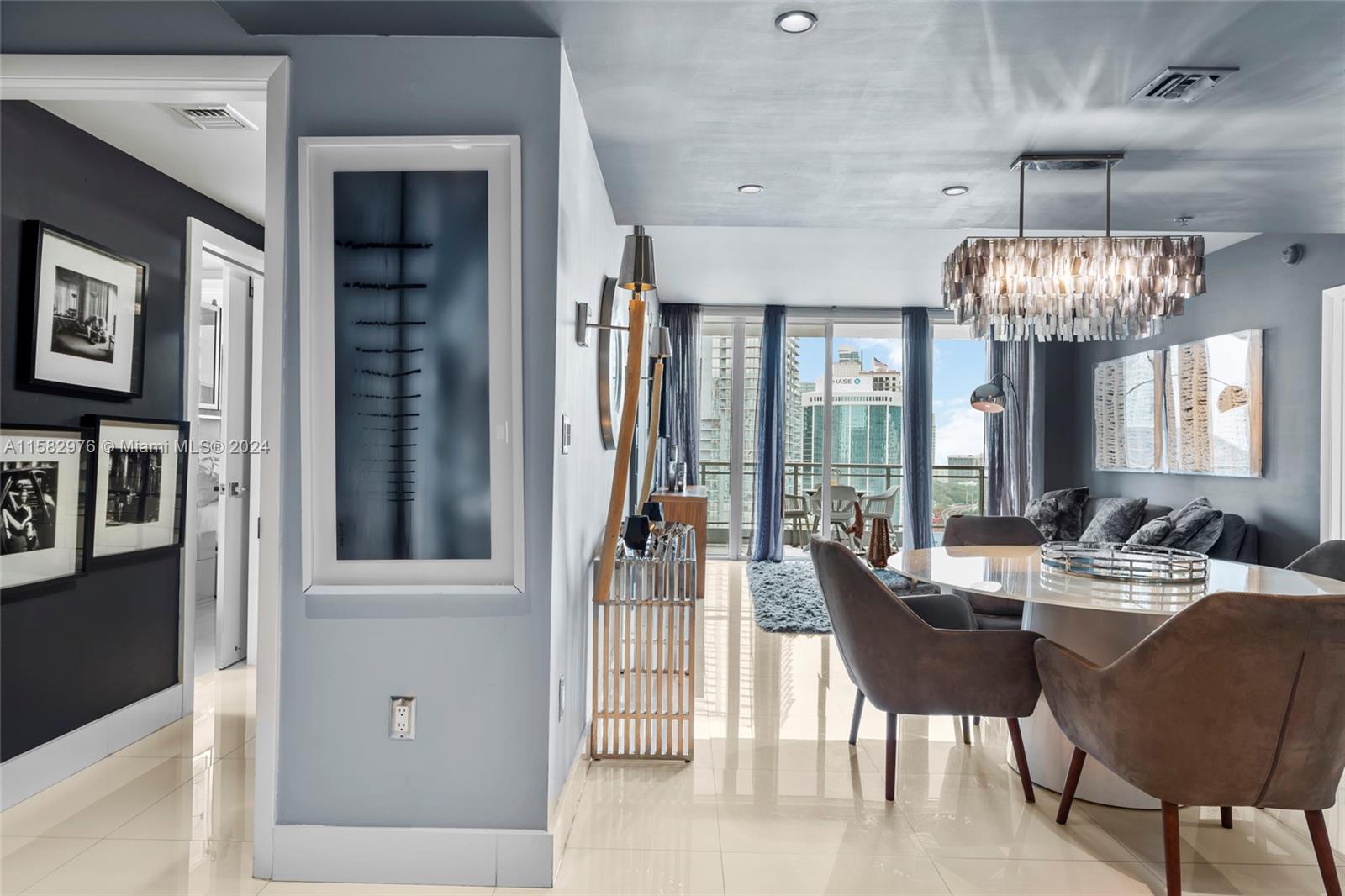 92 Southwest 3rd Street, Unit 2303 Miami, FL 33130 - Photo 27 of 35 a living room with furniture a chandelier and a large window