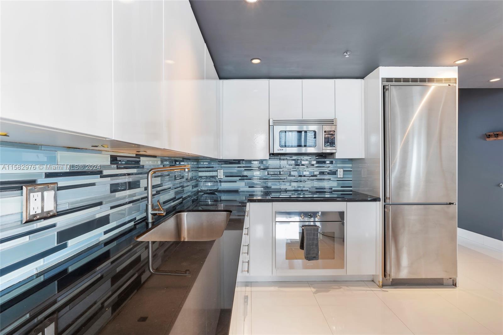 92 Southwest 3rd Street, Unit 2303 Miami, FL 33130 - Photo 5 of 35 a kitchen with a refrigerator and a sink