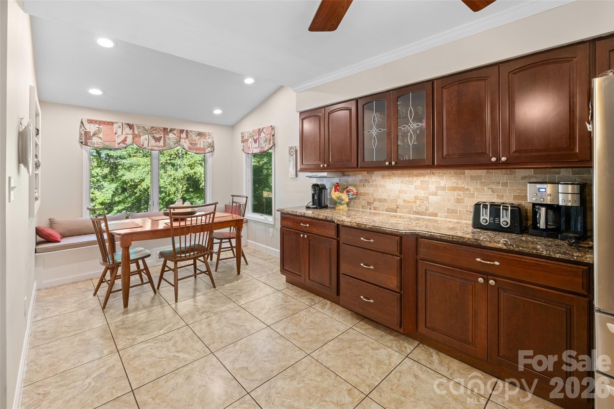 1326 Clifflure Lane Fort Mill, SC 29708 - Photo 18 of 46 a kitchen with stainless steel appliances granite countertop wooden cabinets a dining table and chairs