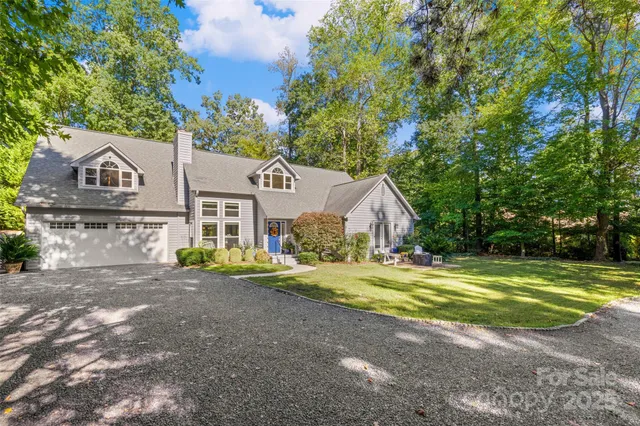 a view of a house with a big yard and large trees