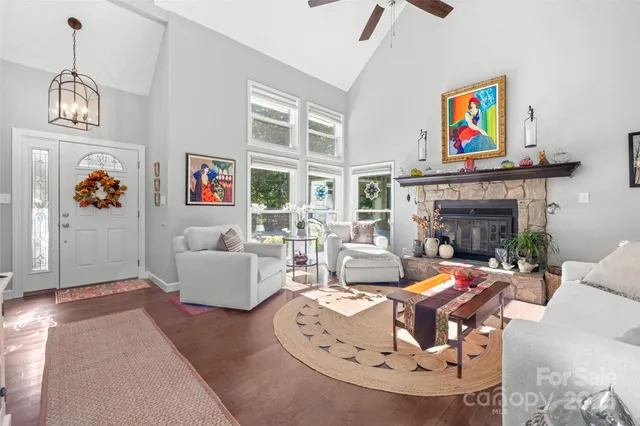 a living room with furniture a fireplace and a chandelier