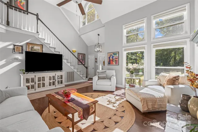 a living room with furniture a flat screen tv and a floor to ceiling window