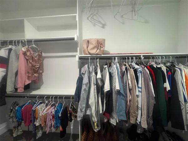 a view of walk in closet with clothes