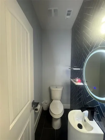 a bathroom with a toilet a sink and a mirror