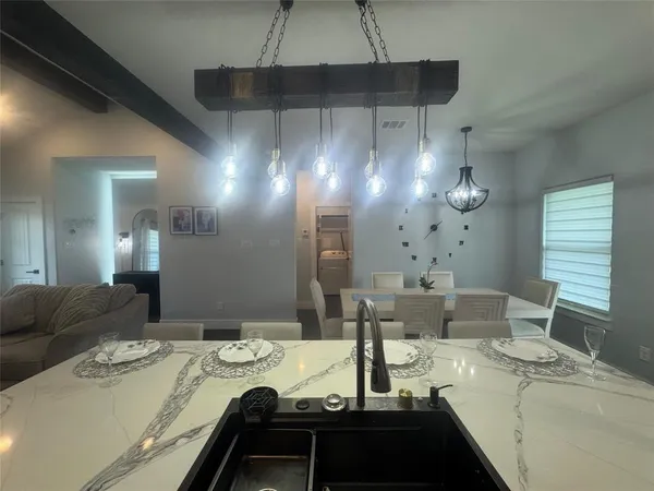 a kitchen with a table chairs and a chandelier