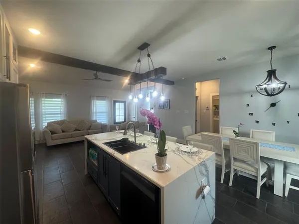 a kitchen with a table chairs and white cabinets