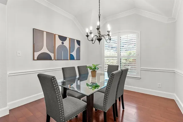 a dining room with furniture a chandelier and wooden floor