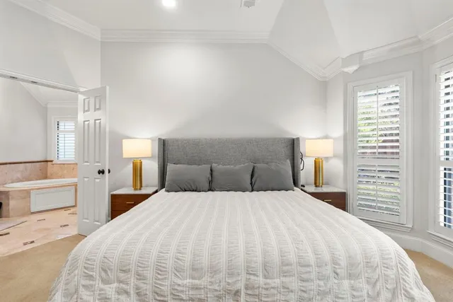 a large bedroom with a bed and large windows