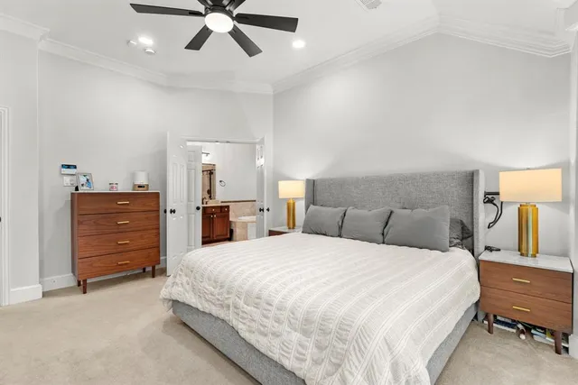 a spacious bedroom with a bed and ceiling fan