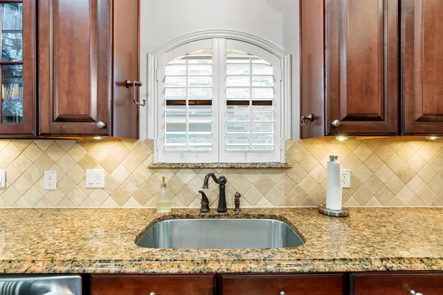 a view of a kitchen with granite countertop a sink and a window