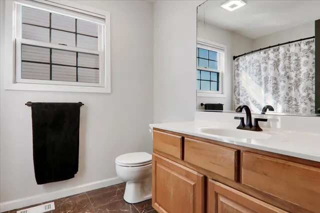 a bathroom with a toilet sink and mirror