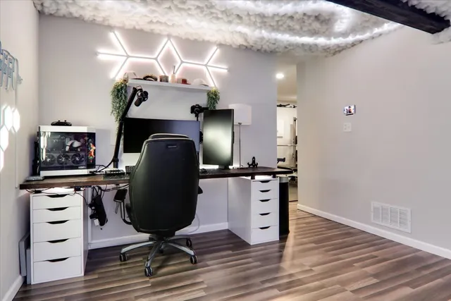 a view of a workspace with furniture and wooden floor