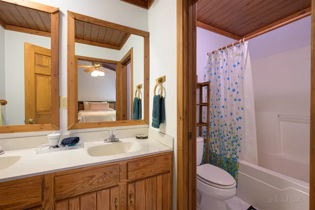 a bathroom with a sink toilet double vanity and shower