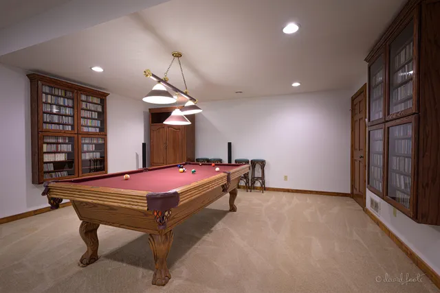 a room with pool table and windows