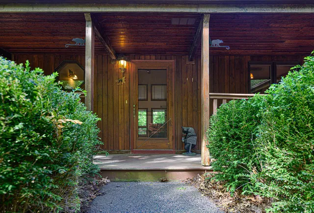 a view of house with potted plants in front of door