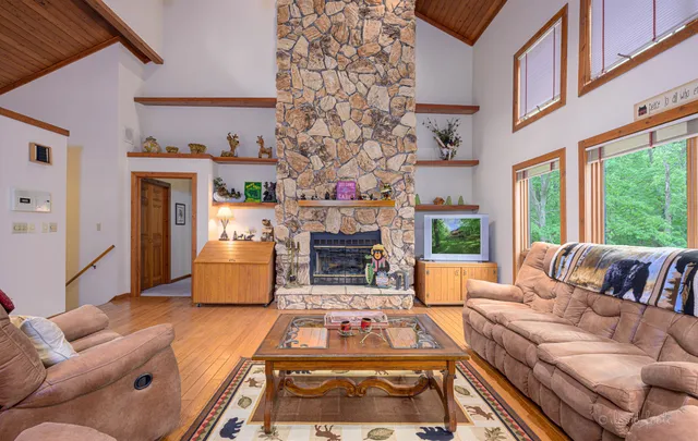 a living room with fireplace furniture and a large window