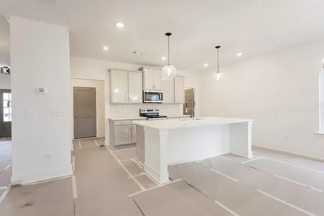 a kitchen with white cabinets and refrigerator