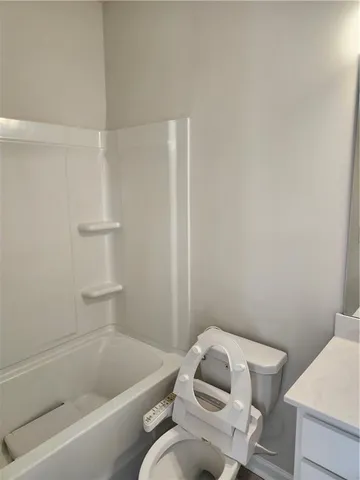 a white toilet and tub sitting next to a bathroom sink