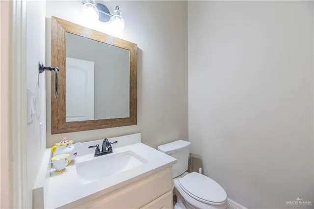 a bathroom with a sink vanity mirror and toilet