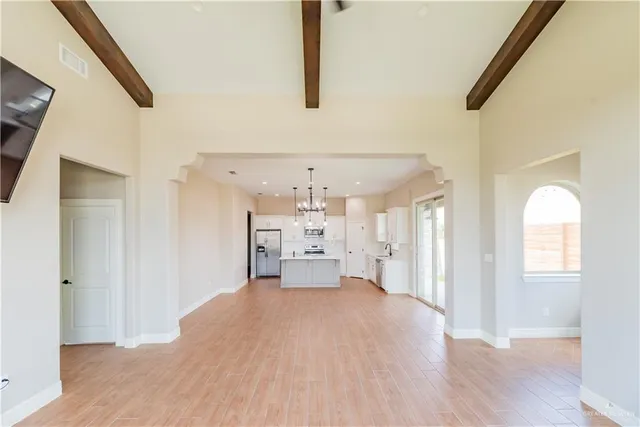 a view of a big room with wooden floor and windows