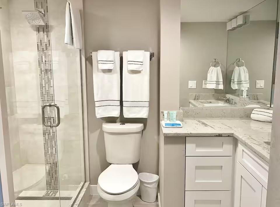 600 Neapolitan Way, Unit 341 Naples, FL 34103 - Photo 13 of 28 a bathroom with a sink a toilet and shower