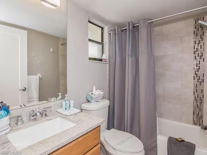 600 Neapolitan Way, Unit 341 Naples, FL 34103 - Photo 15 of 28 a bathroom with a sink vanity mirror and toilet