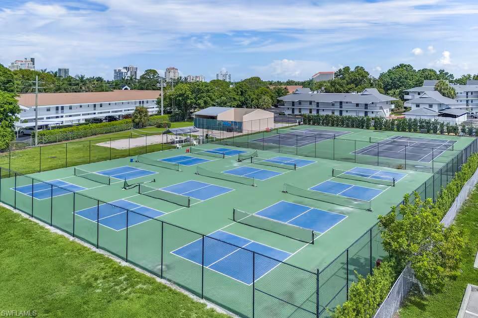 600 Neapolitan Way, Unit 341 Naples, FL 34103 - Photo 20 of 28 an aerial view of a tennis ground with large trees