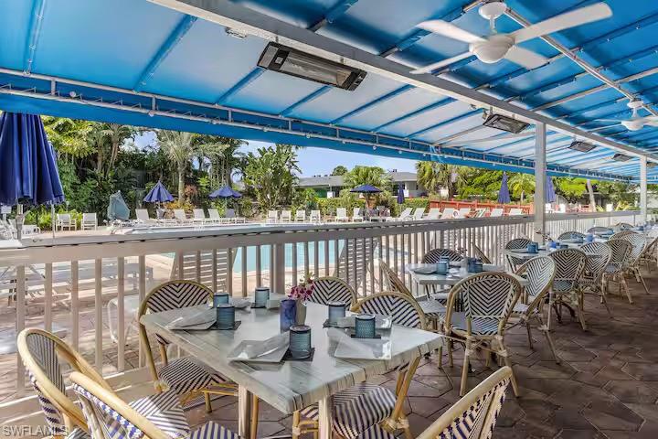 600 Neapolitan Way, Unit 341 Naples, FL 34103 - Photo 22 of 28 a view of a chairs and table in patio
