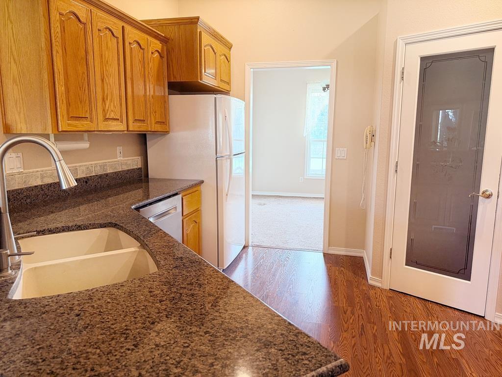 5875 Diamond Ridge Way Nampa, ID 83686 - Photo 14 of 32 Spacious kitchen featuring wood cabinetry, granite countertops, stainless steel appliances, and a curved gooseneck faucet