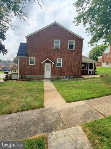 a view of a house with a yard and sitting area