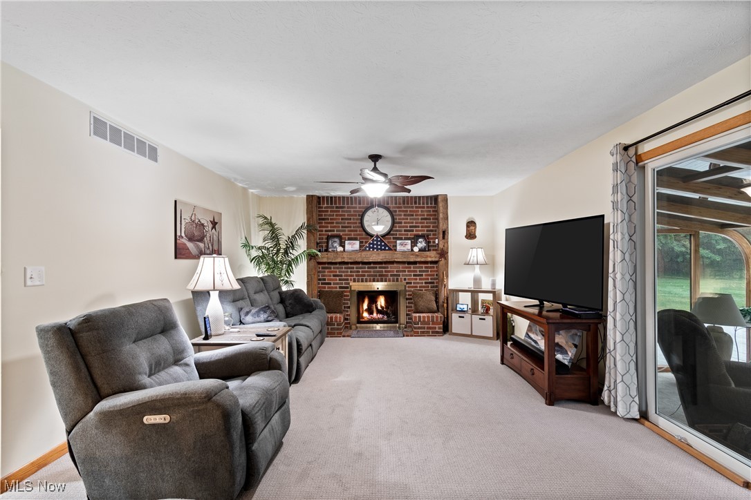 4640 Sherman Road Kent, OH 44240 - Photo 6 of 37 Living area featuring a brick fireplace, light colored carpet, and a ceiling fan