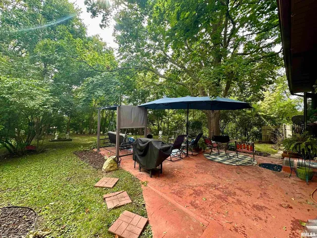 a view of a patio with table and chairs under an umbrella