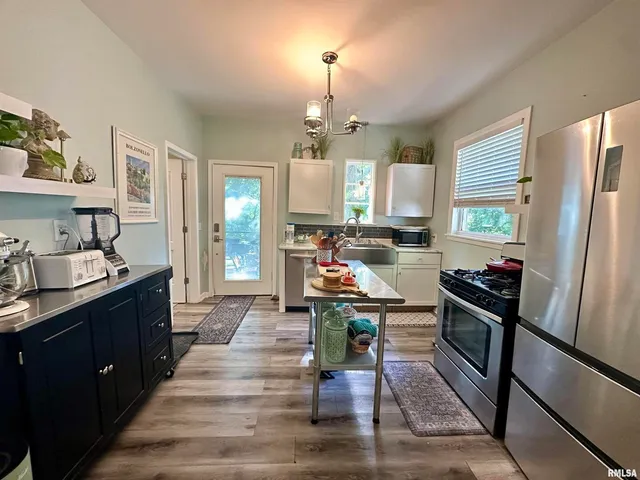 a kitchen with stainless steel appliances granite countertop a refrigerator stove and sink