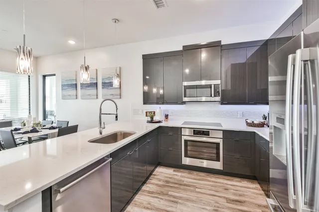 a kitchen with stainless steel appliances granite countertop a sink stove and refrigerator
