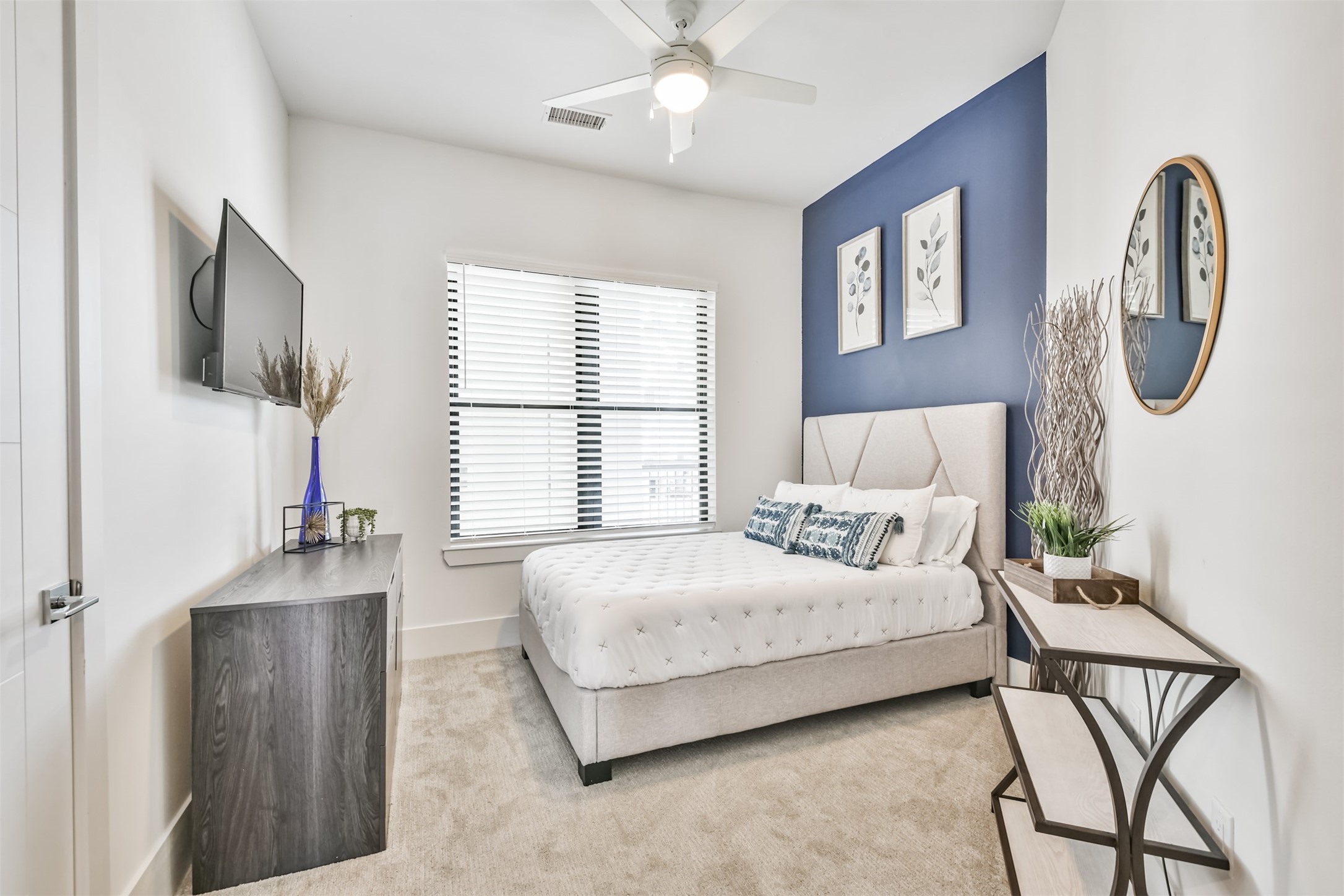 199 Waterpoint Court, Unit 106 Conroe, TX 77304 - Photo 28 of 50 a bedroom with a bed a chandelier and mirror