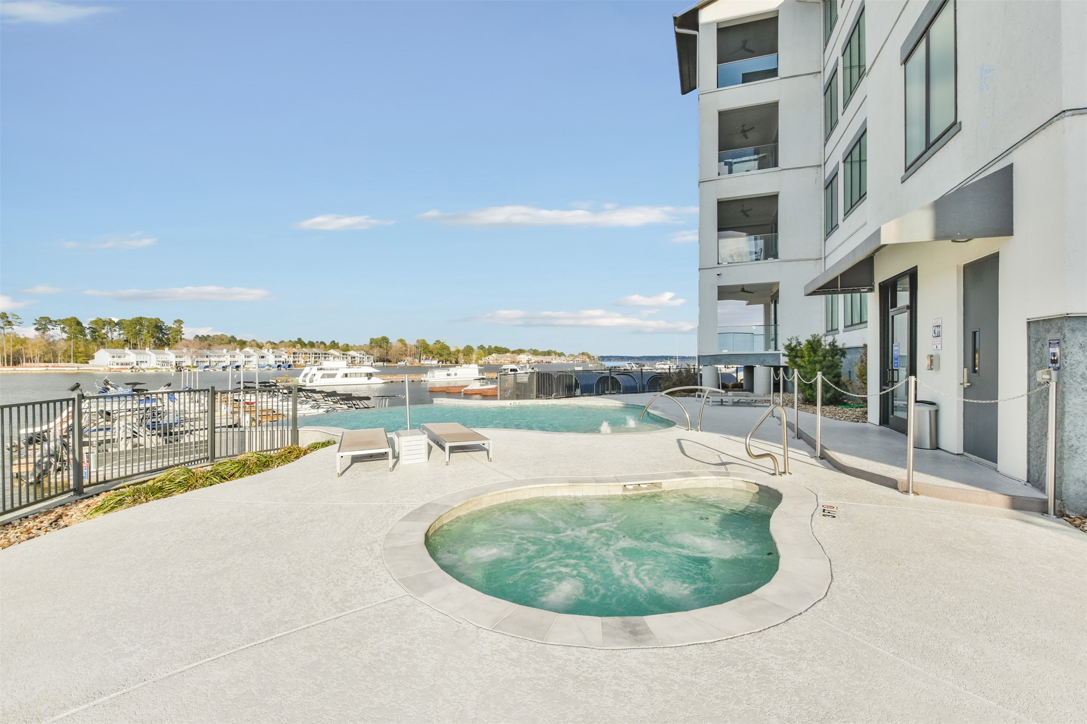 199 Waterpoint Court, Unit 106 Conroe, TX 77304 - Photo 40 of 50 a swimming pool with outdoor seating and yard